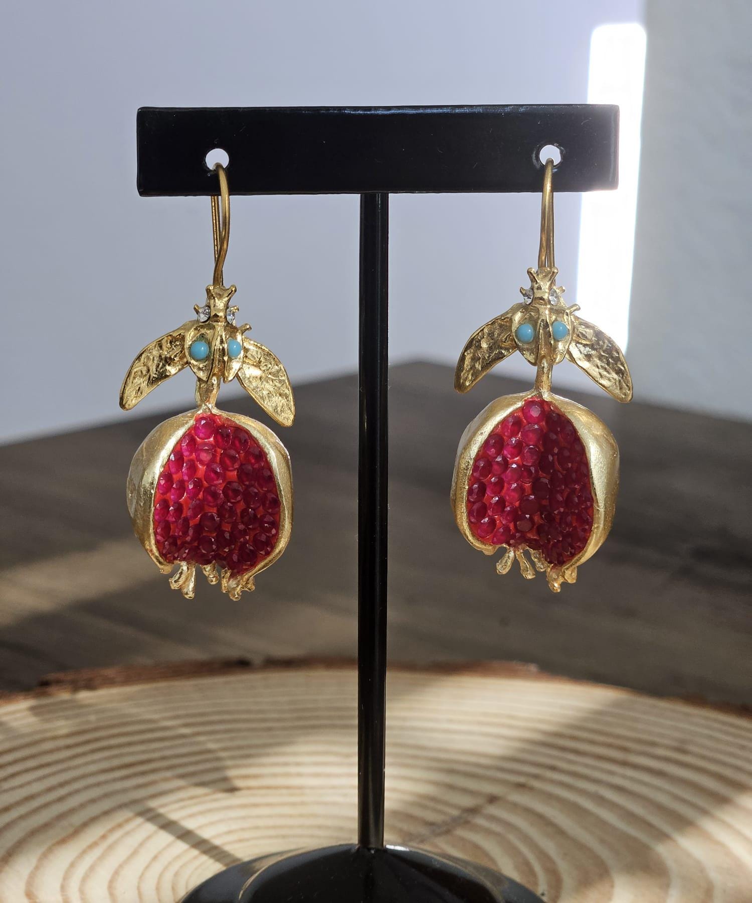 A bronze and gold-plated pomegranate earring combines the earthy tones of bronze with the luxe finish of gold.